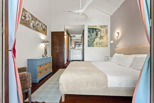 Chambre lumineuse à la villa Les Balcons D'oyster Pond à Saint-Martin avec lit king, commode bleue et équipements modernes