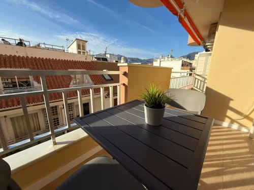 Terraza soleada de apartamento frente al mar en Fuengirola con vistas a la ciudad, maceta y sierra al fondo