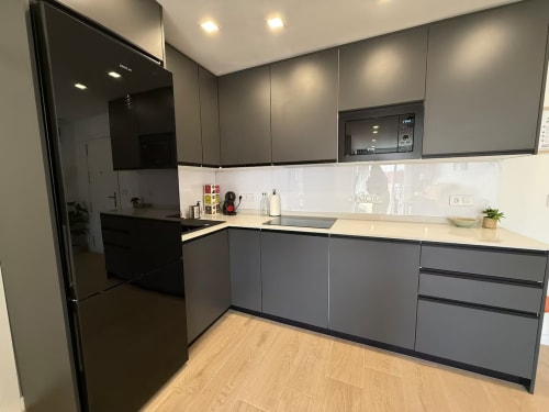 Cocina moderna en apartamento de playa elegante de Grupo Inmohouse, Fuengirola con muebles grises y salpicadero blanco