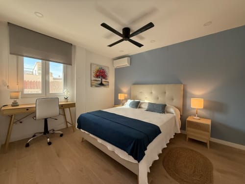 Elegante apartamento soleado en Fuengirola con cama matrimonial, ventilador moderno, escritorio y vistas a la ciudad.