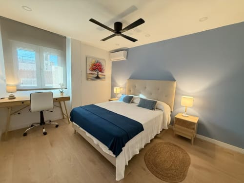 Elegante apartamento de playa soleado en Fuengirola con cama moderna, zona de trabajo, ventilador de techo y vistas a la ciudad