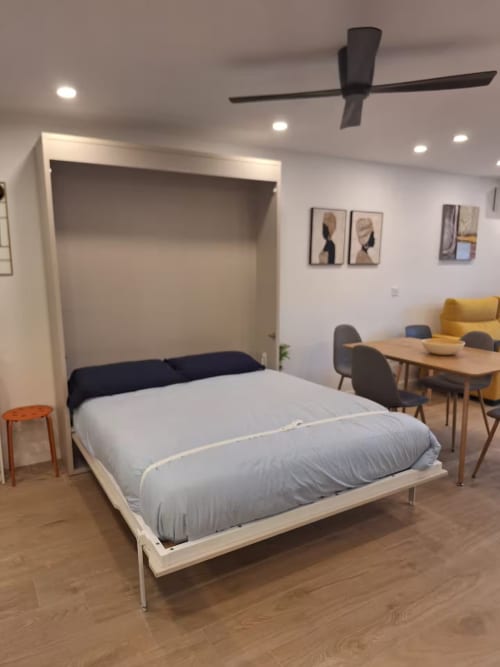 Dormitorio moderno con cama abatible en elegante apartamento de Fuengirola de Grupo Inmohouse, con zona de comedor y vistas a la ciudad
