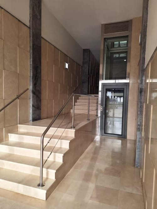 Escalera moderna con barandilla metálica en el vestíbulo de un elegante apartamento de playa en Fuengirola, tonos neutros