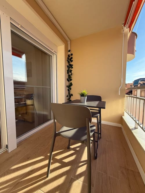 Apartamento soleado en Fuengirola con balcón, mesa, silla y vistas a la ciudad de Grupo Inmohouse