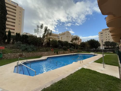 Moderno complejo residencial frente al mar en Fuengirola con piscina de resort, terraza y vistas a la ciudad