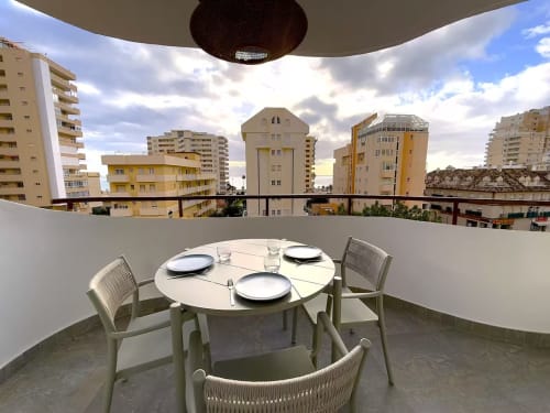 Moderno apartamento soleado en la playa de Fuengirola con terraza comedor con vistas a edificios de la ciudad