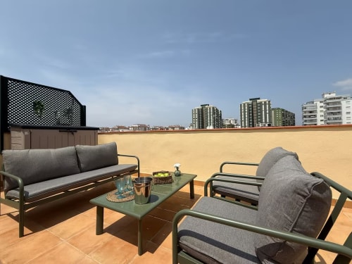 Soleada terraza en azotea con zona de estar en apartamento frente al mar en Fuengirola, con vistas al horizonte de la ciudad
