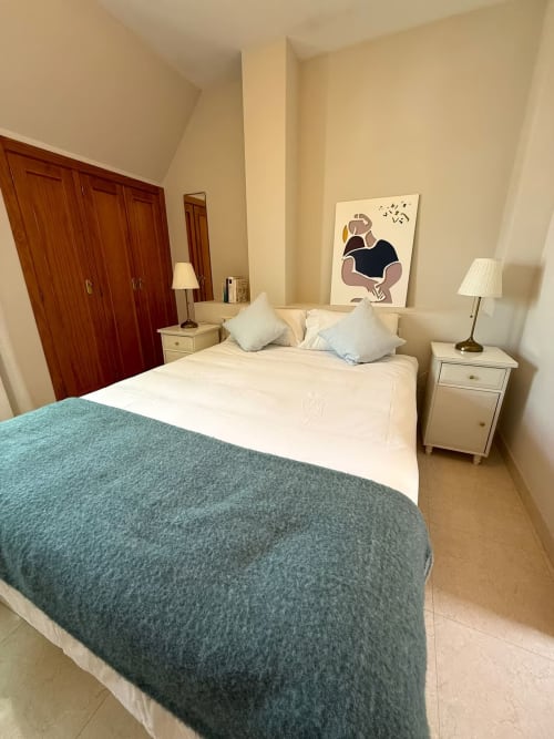 Dormitorio soleado en apartamento de Fuengirola con camas gemelas, ropa de cama crema, vistas a la montaña y comodidades modernas