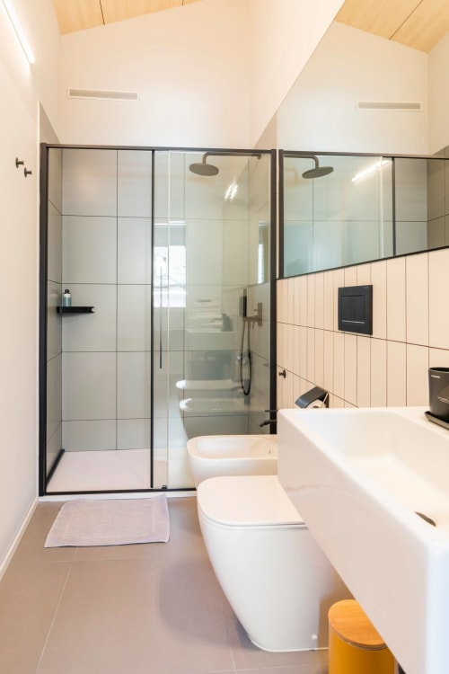 Modern bathroom at Camere d'Aria B&B in Locana with glass shower, white toilet, and pedestal sink