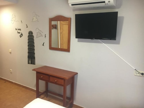 Habitación doble moderna en Hostal Imaginatelo con TV de pantalla plana, escritorio de madera, espejo y decoración de pared europea en Carrascosa