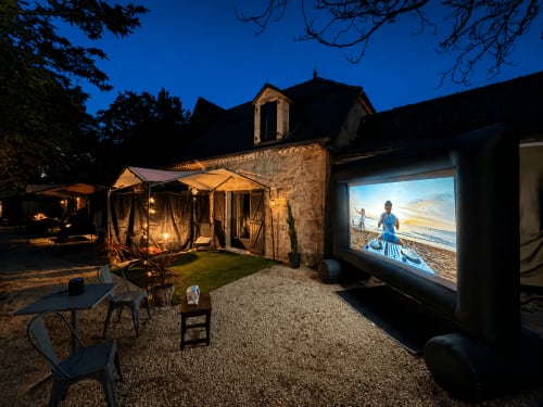 Cinéma en plein air le soir au Domaine Valenquercy B&B à Le Vignon-en-Quercy, avec écran de projection, zone de détente et éclairage