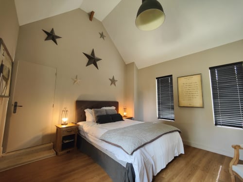 Chambre Chelsea au Le Paddock B&B avec lit queen-size, décoration murale étoilée, vue sur jardin et planchers en bois