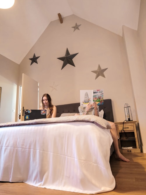 Femme en chemise rayée lisant dans la chambre Chambre Chelsea du Paddock B&B, avec des étoiles au plafond et vue sur le jardin