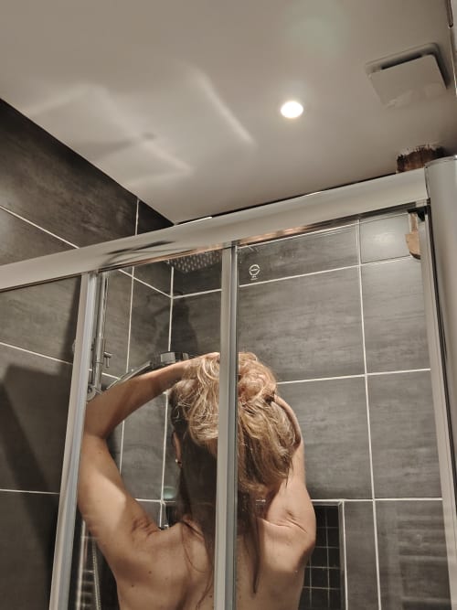 Salle de bains moderne avec douche vitrée et murs carrelés à La Drenne
