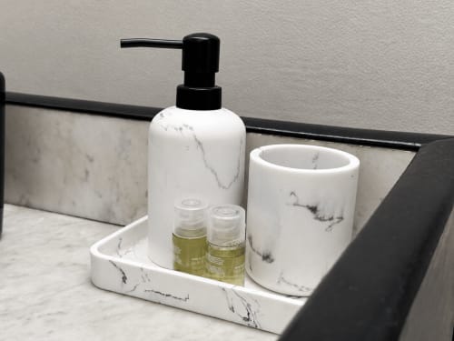 Marble bathroom amenities set at Domaine Valenquercy B&B with soap dispenser, cup, and complimentary toiletries in Le