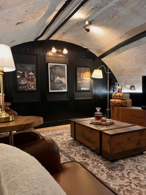 Luxurious lounge in L'Arcade Secrète apartment at Wellkhome Bordeaux with black paneling, wooden furniture, arched ceiling,