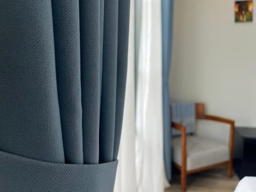 Rideaux bleus et voilages blancs aérés dans une chambre moderne de l'hôtel Cybade, Phu Quoc