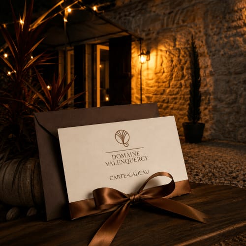 Élégante carte-cadeau du Domaine Valenquercy B&B au Vignon-en-Quercy, présentée sous l'éclairage du soir de la cour