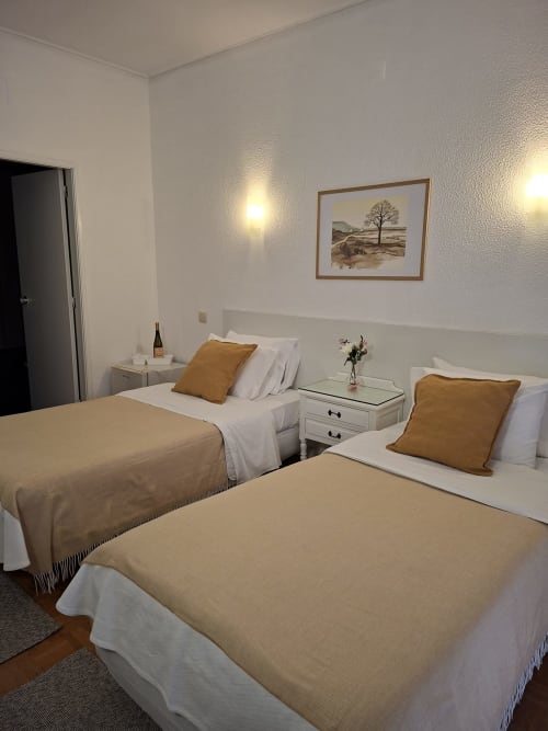 Twin bedroom at Porta 80 House in Braga with two beds, warm décor, and city views