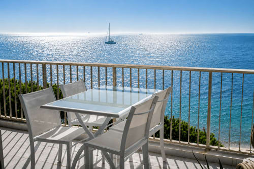 Balcon vue mer d'un appartement en bord de mer à Cannes avec table à manger et voiliers