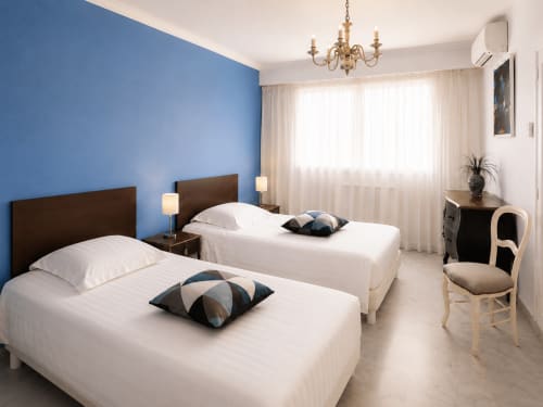 Lits jumeaux dans chambre climatisée avec mur bleu, appartement vue mer Le FETTOLINA, Cannes Palm Beach