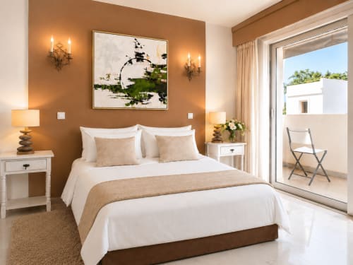 Chambre élégante de l'appartement Le FETTOLINA à Cannes avec murs en terre cuite, balcon vue mer et équipements modernes