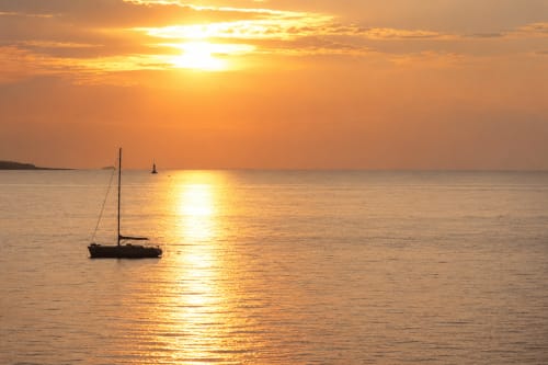 Coucher de soleil sur la mer Méditerranée avec voilier, vue depuis un appartement de prestige à Cannes