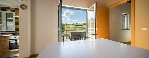 Modern kitchen and dining area with orchard views at Quinta Boa Vida's Orchard View Villa in Alcobaça, Portugal