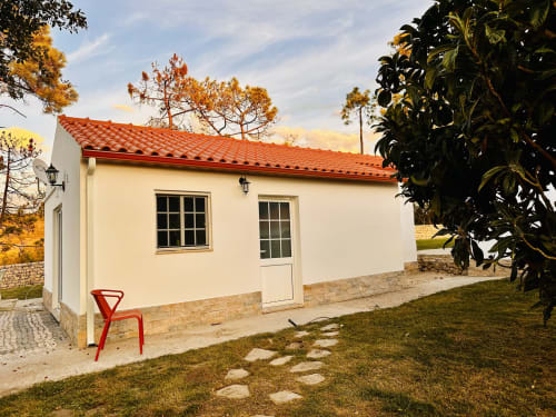 Mountain View Chalet at Quinta Boa Vida in Alcobaça with red-tiled roof, cream-colored walls, and red chair on patio