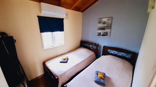 Twin bedroom at Quinta Boa Vida mountain view chalet in Alcobaça with wooden beds and window