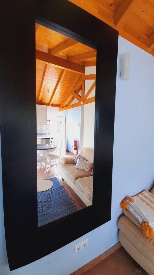 Mirror view of Mountain View Chalet interior at Quinta Boa Vida, showing wooden beamed ceiling, kitchen, seating area, and