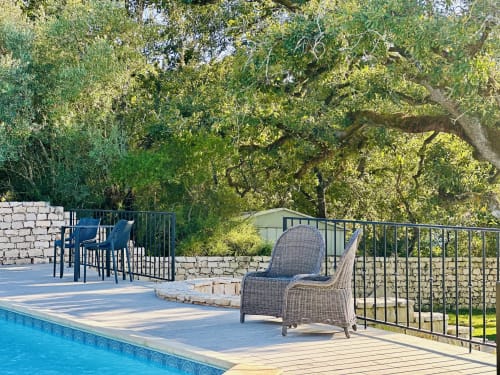 Quinta Boa Vida cottage poolside patio with wicker seating, dining area, and lush trees in Alcobaça, Portugal