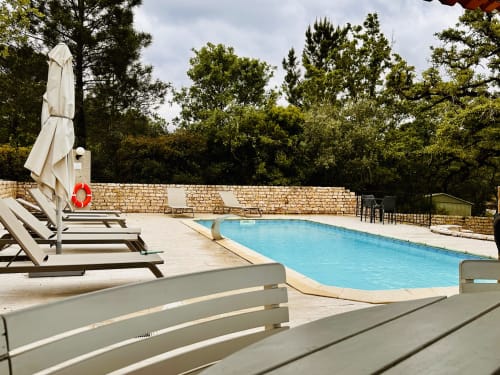 Quinta Boa Vida pool area in Alcobaça with loungers, umbrella, and stone terrace surrounded by trees