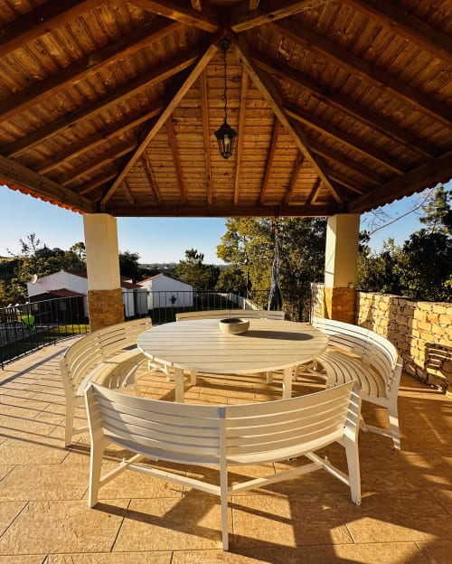 Covered wooden pavilion with white lounge chairs and round table at Quinta Boa Vida cottage in Alcobaça