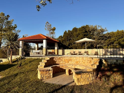 Stone fire pit and outdoor seating at Quinta Boa Vida cottage retreat in Alcobaça, Portugal