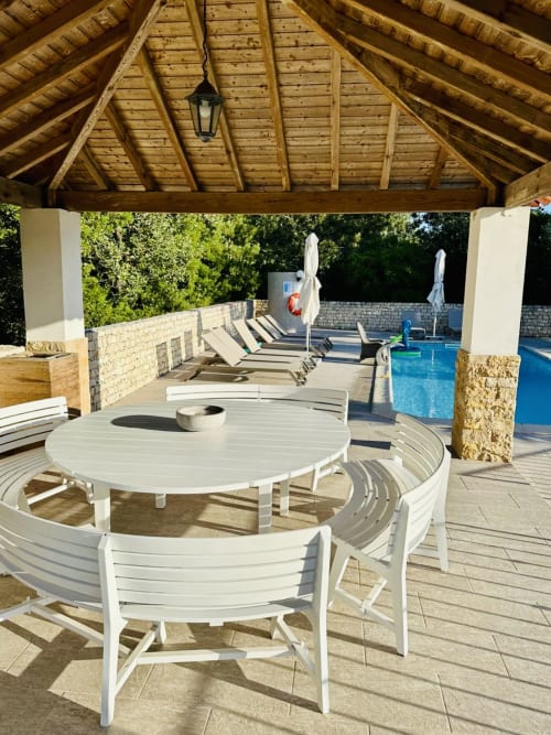 Covered patio at Quinta Boa Vida cottage with white dining furniture overlooking pool and gardens in Alcobaça