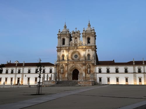 Alcobaca Monastery in Portugal with illuminated white buildings at dusk, near Quinta Boa Vida