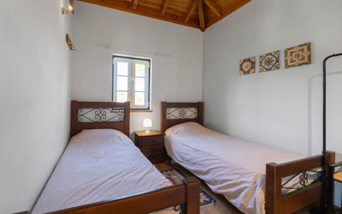 Twin beds in Orchard View Villa at Quinta Boa Vida, Alcobaça with wooden headboards and garden view window