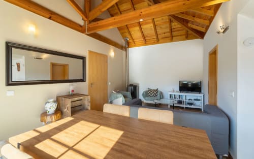 Spacious Orchard View Villa dining and living area with wooden beams, dining table, TV, seating, and garden views at Quinta