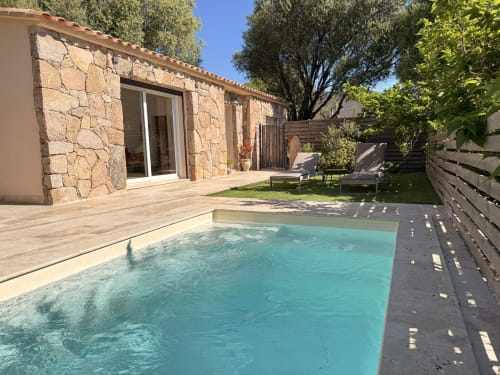Villa de luxe à Figari avec piscine turquoise, terrasse en pierre et équipements modernes dans un jardin verdoyant