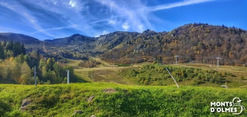Gîte Belloréade à Belloc, France : vue sur la vallée montagnarde, champs verdoyants et collines boisées sous ciel bleu