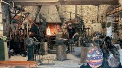 Cour du gîte Belloréade avec cheminée, ambiance rustique en pierre, clients réunis à Belloc