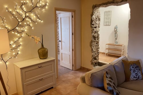 Aconchegante sala de estar no cottage El Sueño de Andalucia com iluminação quente, arco de pedra e vistas para as montanhas em Huércal-Overa