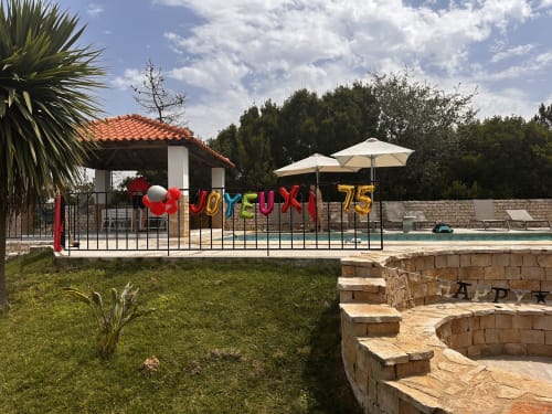 Quinta Boa Vida pool area with colorful 75th celebration bunting, umbrellas, and lush grounds in Alcobaça