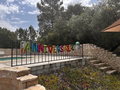 Colorful 'Anniversary' banner on black gate at Quinta Boa Vida cottage in Alcobaça with pool view and garden