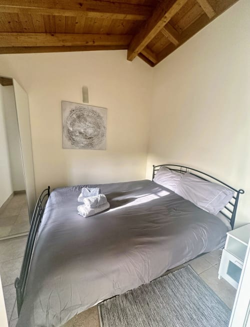 Spacious bedroom with double bed, exposed wooden beams, and natural light at Quinta Boa Vida in Alcobaça, Portugal