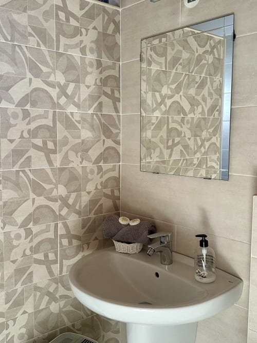 Bathroom sink with decorative tile wall and mirror at Quinta Boa Vida romantic chalet in Alcobaça