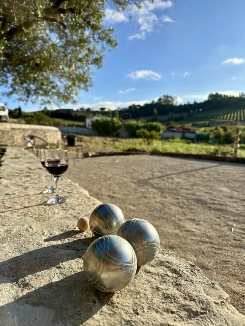 Bocci balls on patio with wine glass overlooking vineyard views at Quinta Boa Vida in Alcobaça