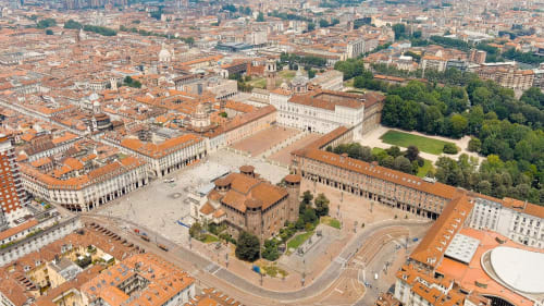 Vista aerea del centro storico di Modena con torre medievale e piazza circondata da edifici con tetti in terracotta