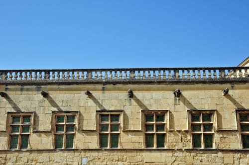 Façade historique en pierre d'Entre Ciel et Lettres avec fenêtres cintrées et balustrade ornementale, France